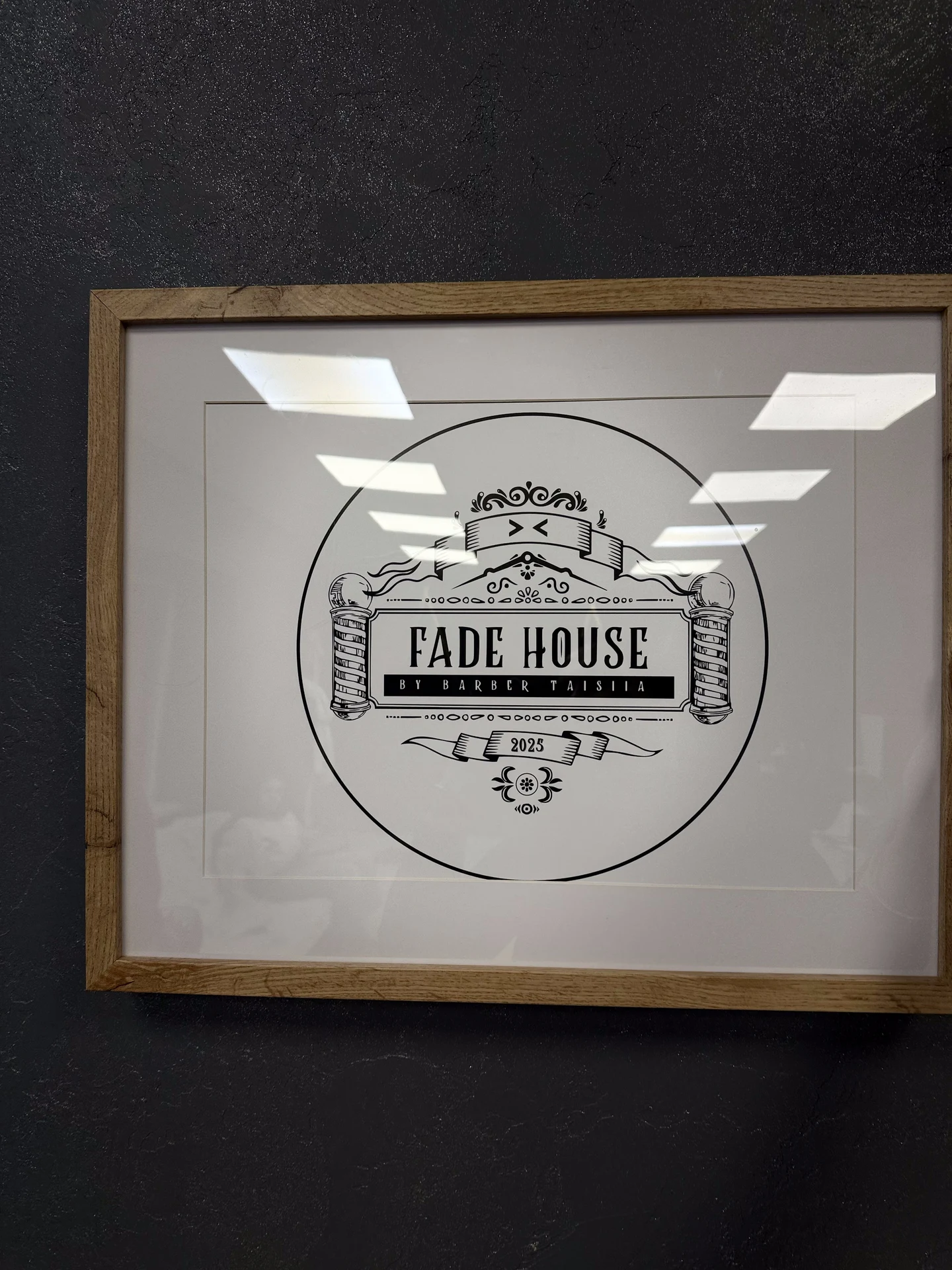 Logo Fade House w ramie — wnętrze barbershopu w Łodzi