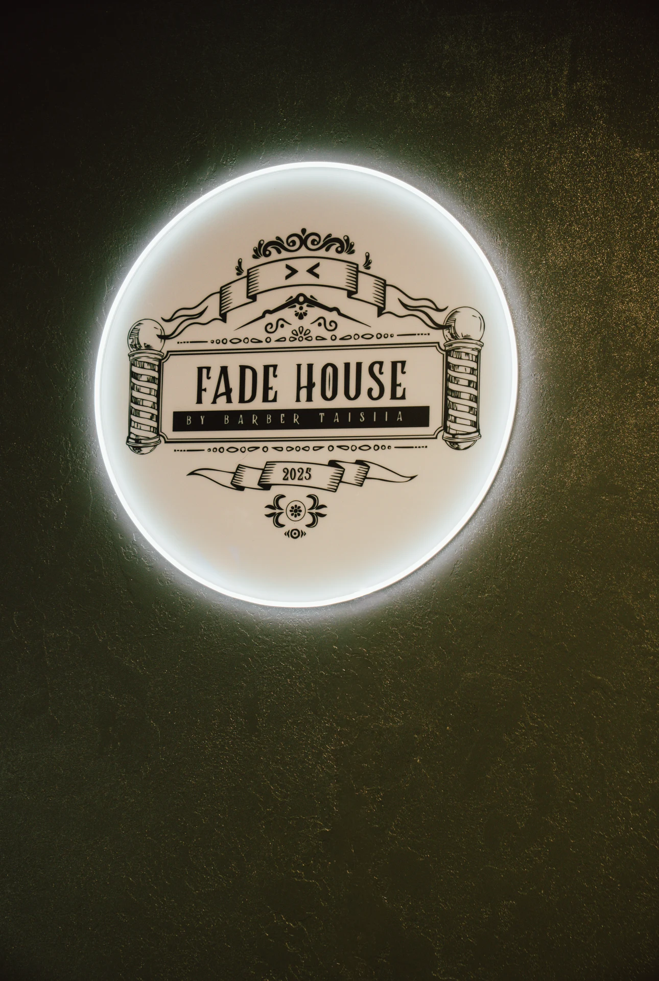 Szyld Fade House na ścianie — wnętrze barbershopu w Łodzi